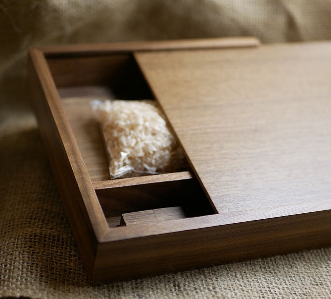 Coffret en bois artisanal avec compartiment et sachet décoratif.