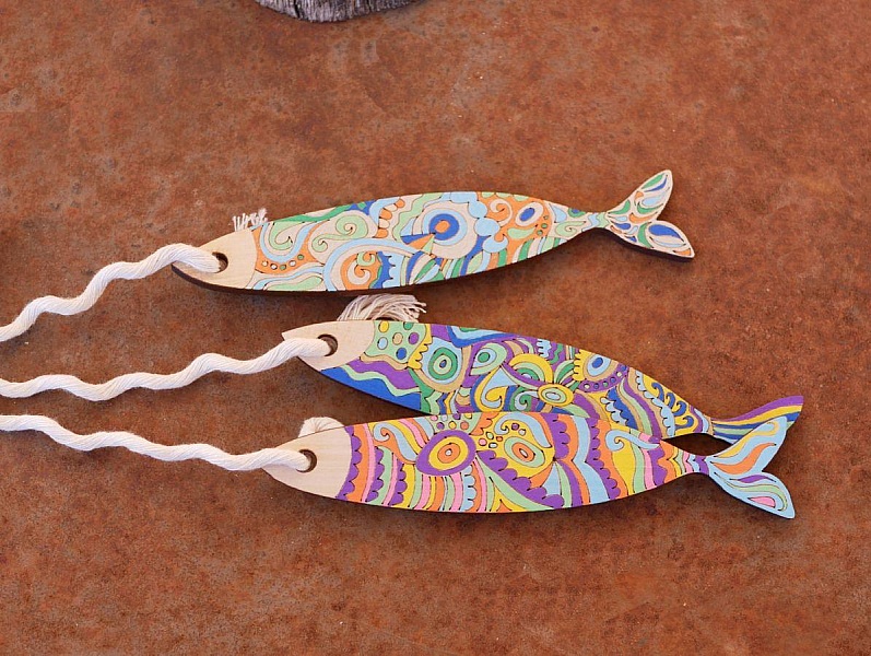 Poissons décoratifs en bois peint avec motifs colorés.