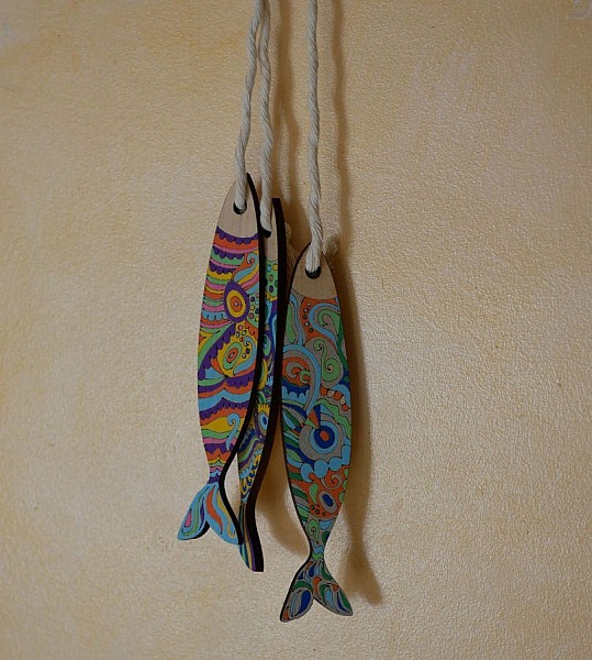 Poissons décoratifs en bois aux motifs colorés suspendus.