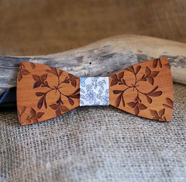 Noeud papillon en bois gravé avec motif floral.