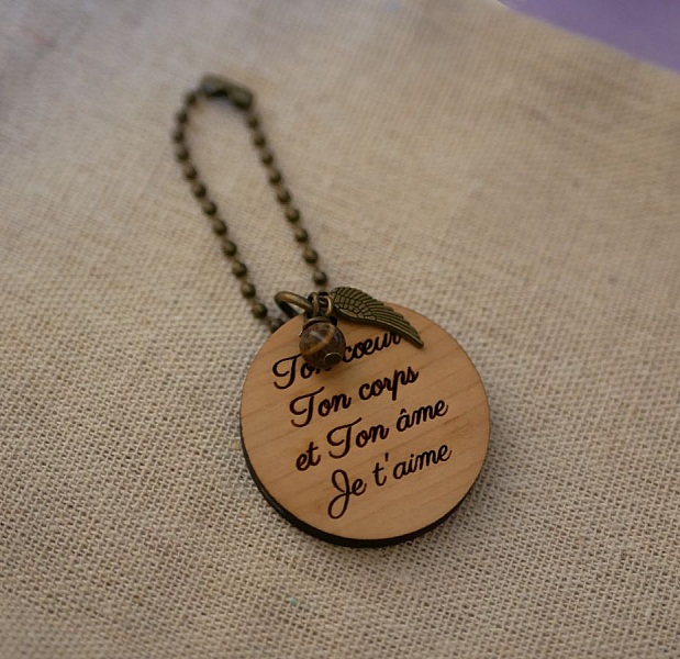 Porte-clé personnalisé en bois avec perle et breloque aile.